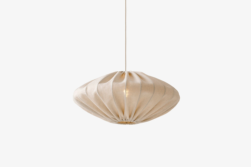 Beżowa lampa wisząca z szerokim falistym kloszem na cienkim przewodzie.