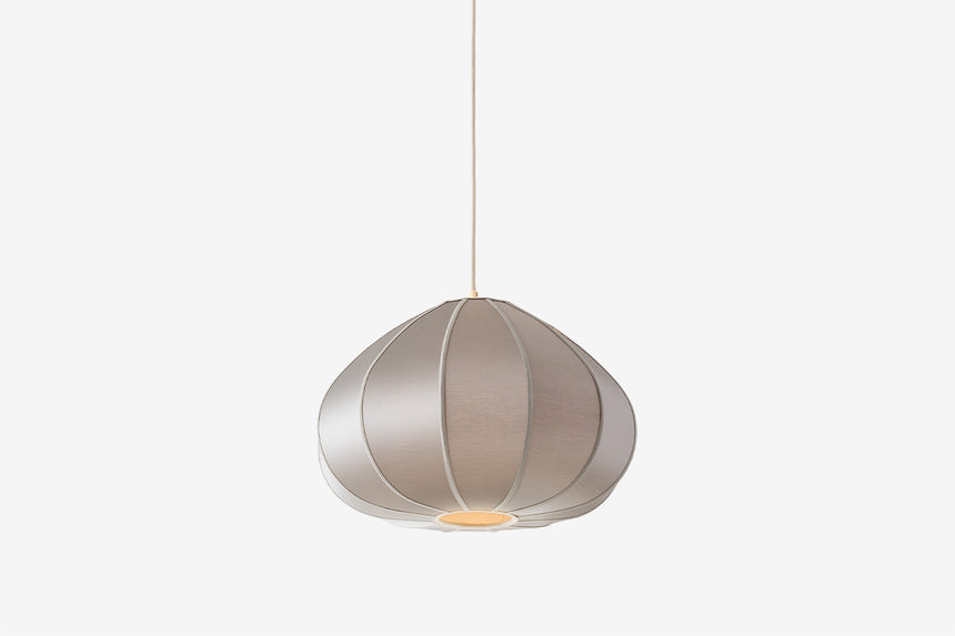 Beżowa lampa wisząca o kulistym segmentowym kloszu na cienkim przewodzie.