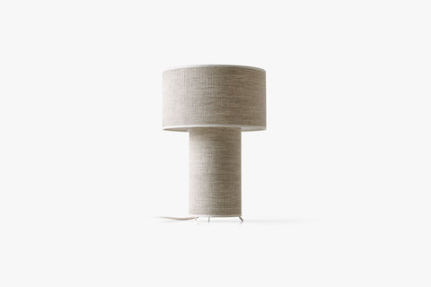 Beżowa lampa stołowa z cylindrycznym abażurem i prostą podstawą.