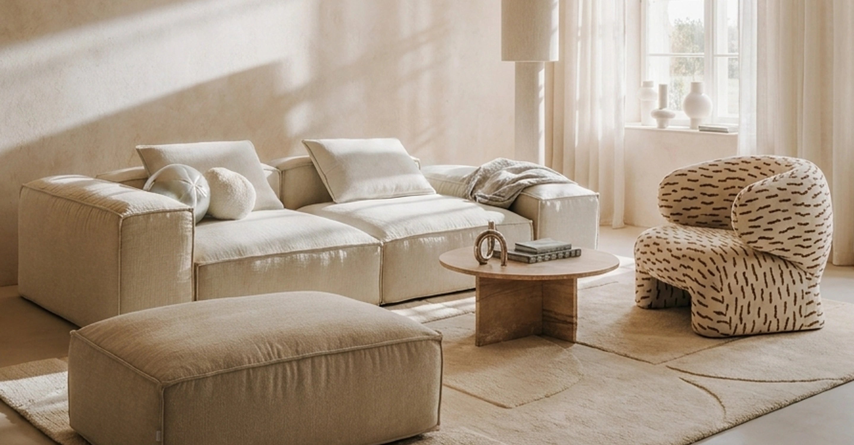 Jasny salon z modułową sofą, pufą i wzorzystym fotelem IWC HOME